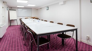 A conference room with a long table, chairs, a whiteboard, and a projector screen. - Hotel Au Patio Morand (Lyon)