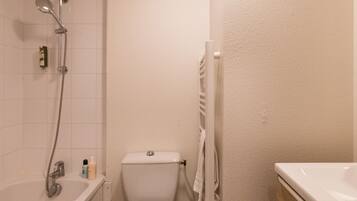 Un baño pequeño con bañera, inodoro y ducha.