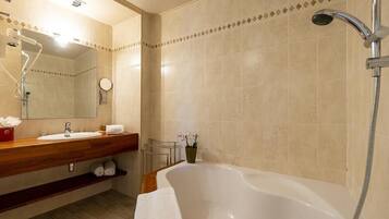 A bathroom with a bathtub, a sink, a mirror, and a shower.