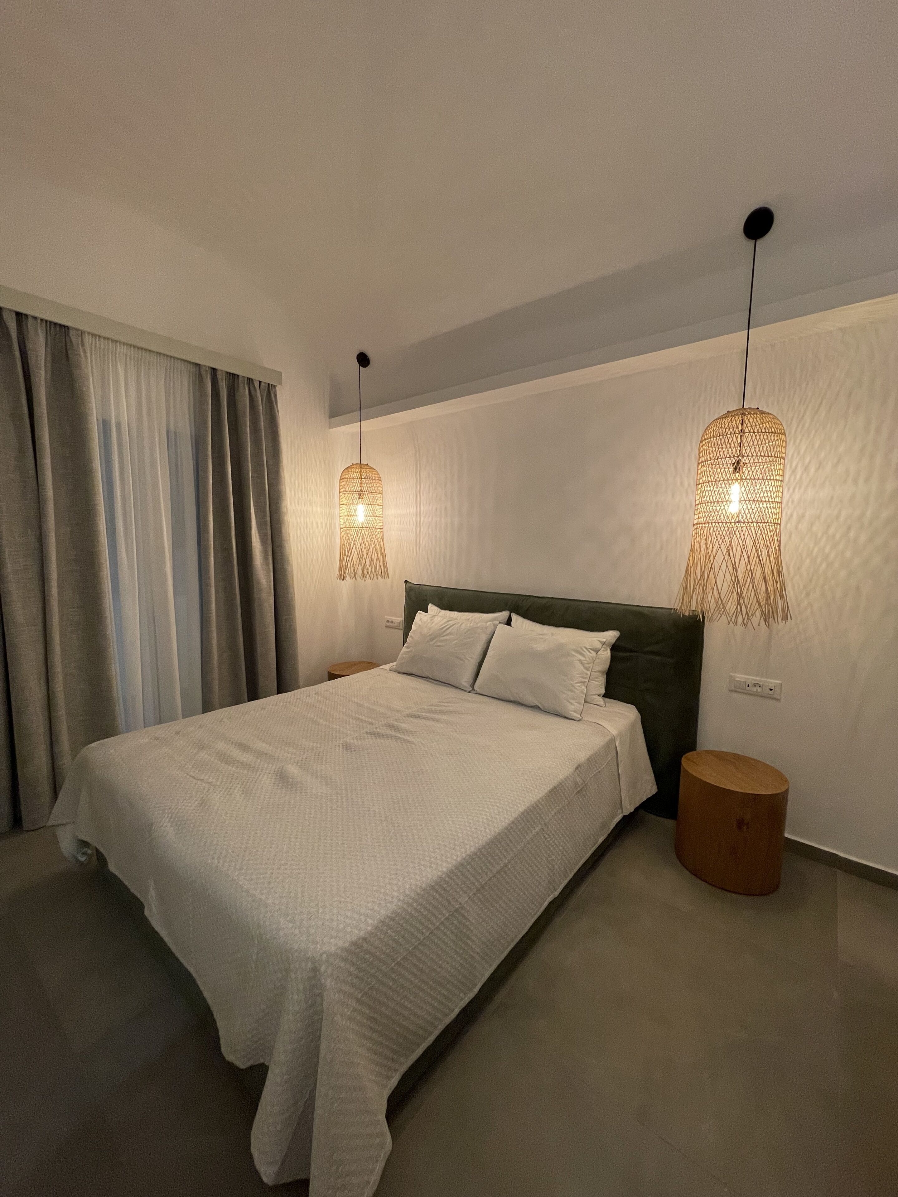 A modern bedroom with a large bed, two bedside tables, and a nightstand.