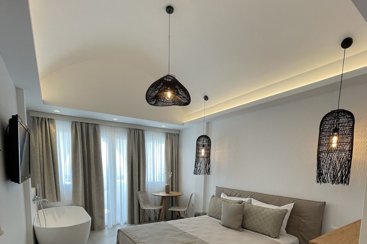 Een moderne slaapkamer met een groot bed, een ronde tafel en twee hanglampen.