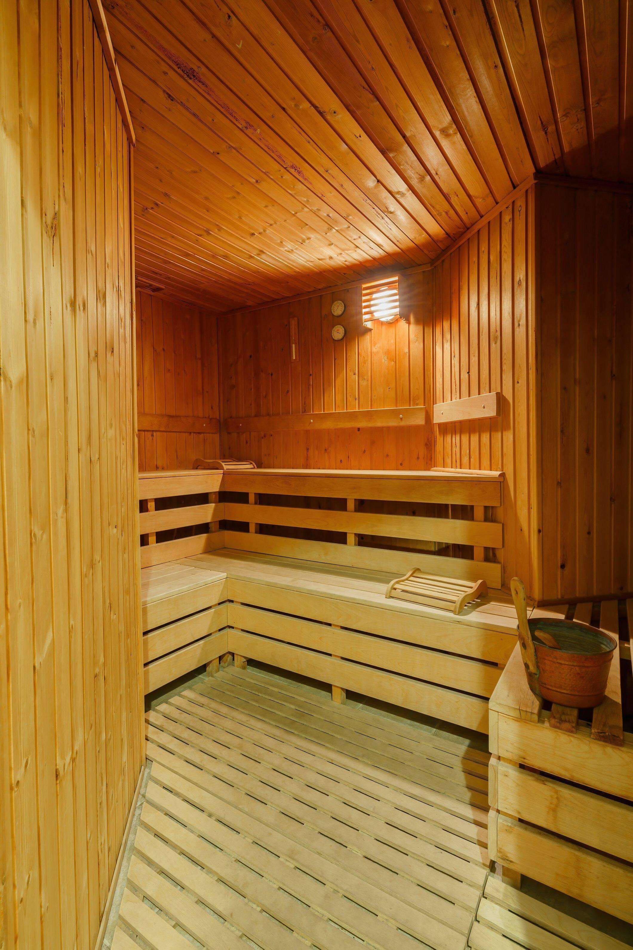 Una sauna de madera con bancos y un asiento de banco.