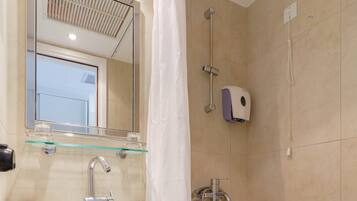 A bathroom with a white sink, mirror, and shower.