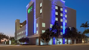 Un hotel moderno con un letrero llamativo, varios pisos y una fachada bien iluminada.