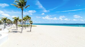Una playa con palmeras y un cielo azul despejado.