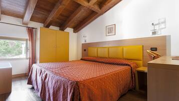 Ein Schlafzimmer mit Bett, Schrank, Nachttisch und Fenster.