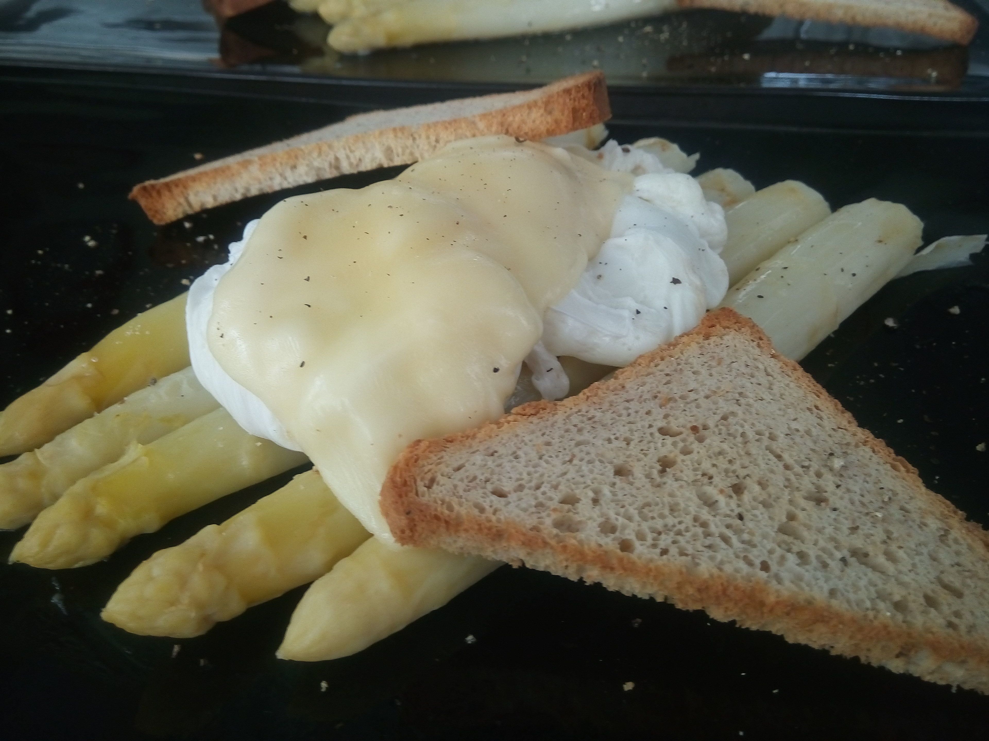 A plate with French fries, a slice of toast, and a poached egg with hollandaise sauce.