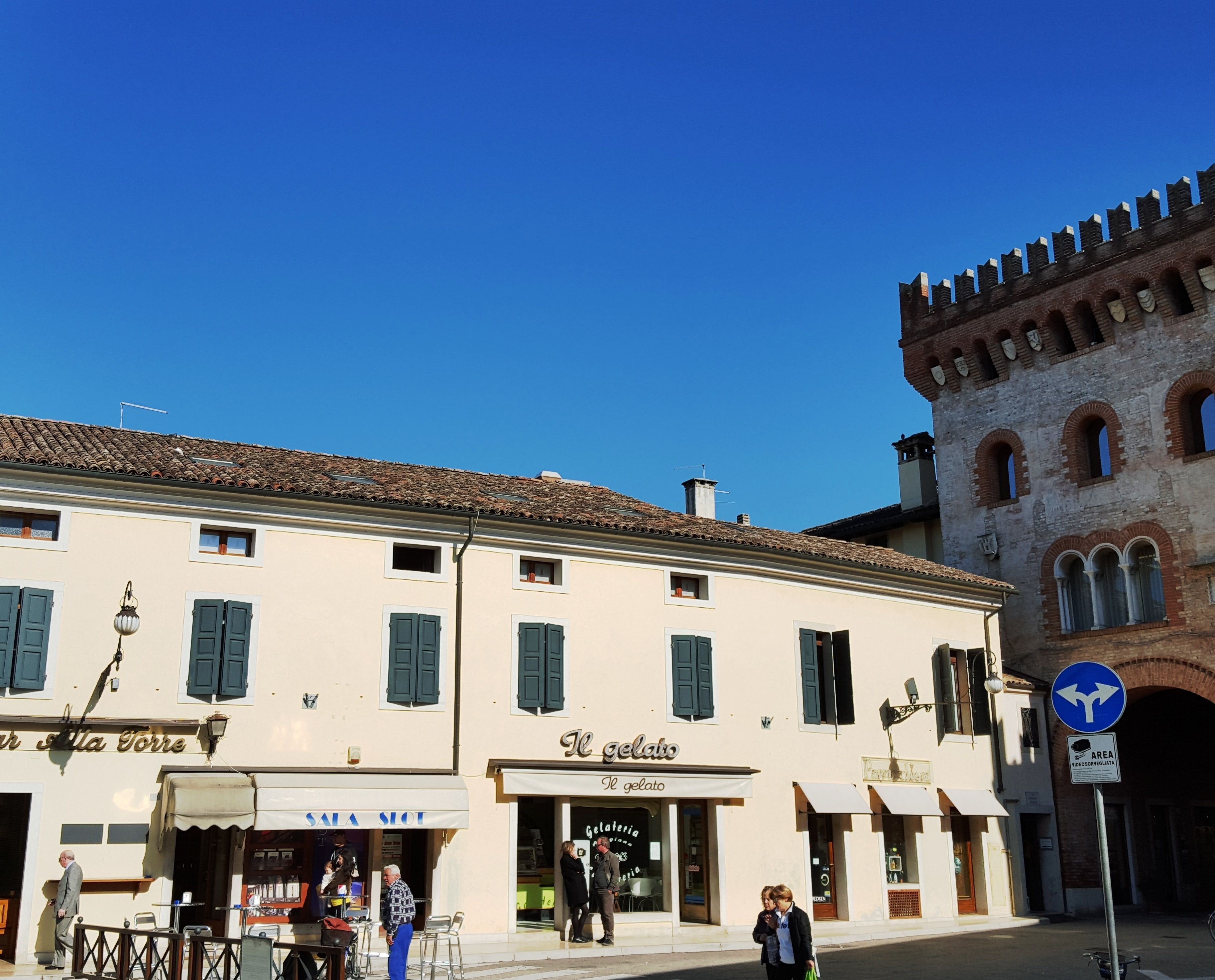 A street with a building featuring a gelateria and a sign for "Il gelato."