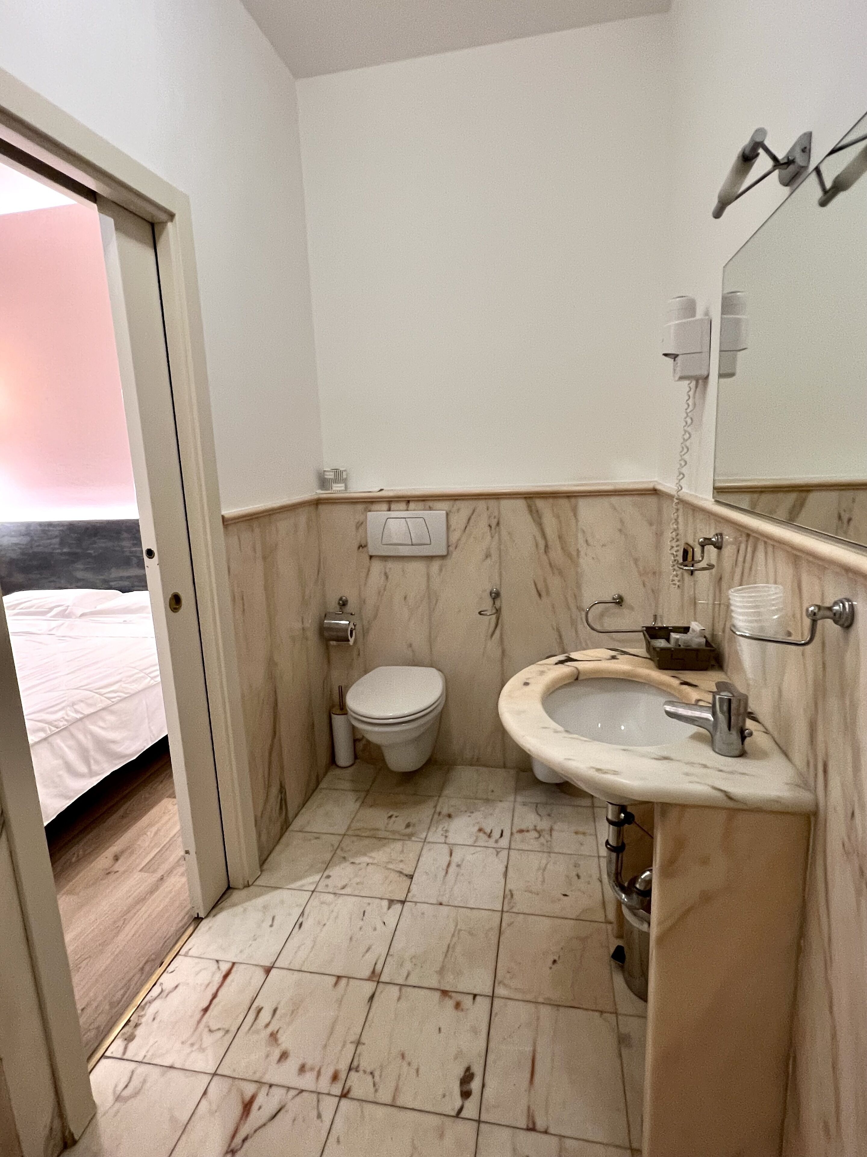 Un baño con inodoro, lavabo y espejo.
