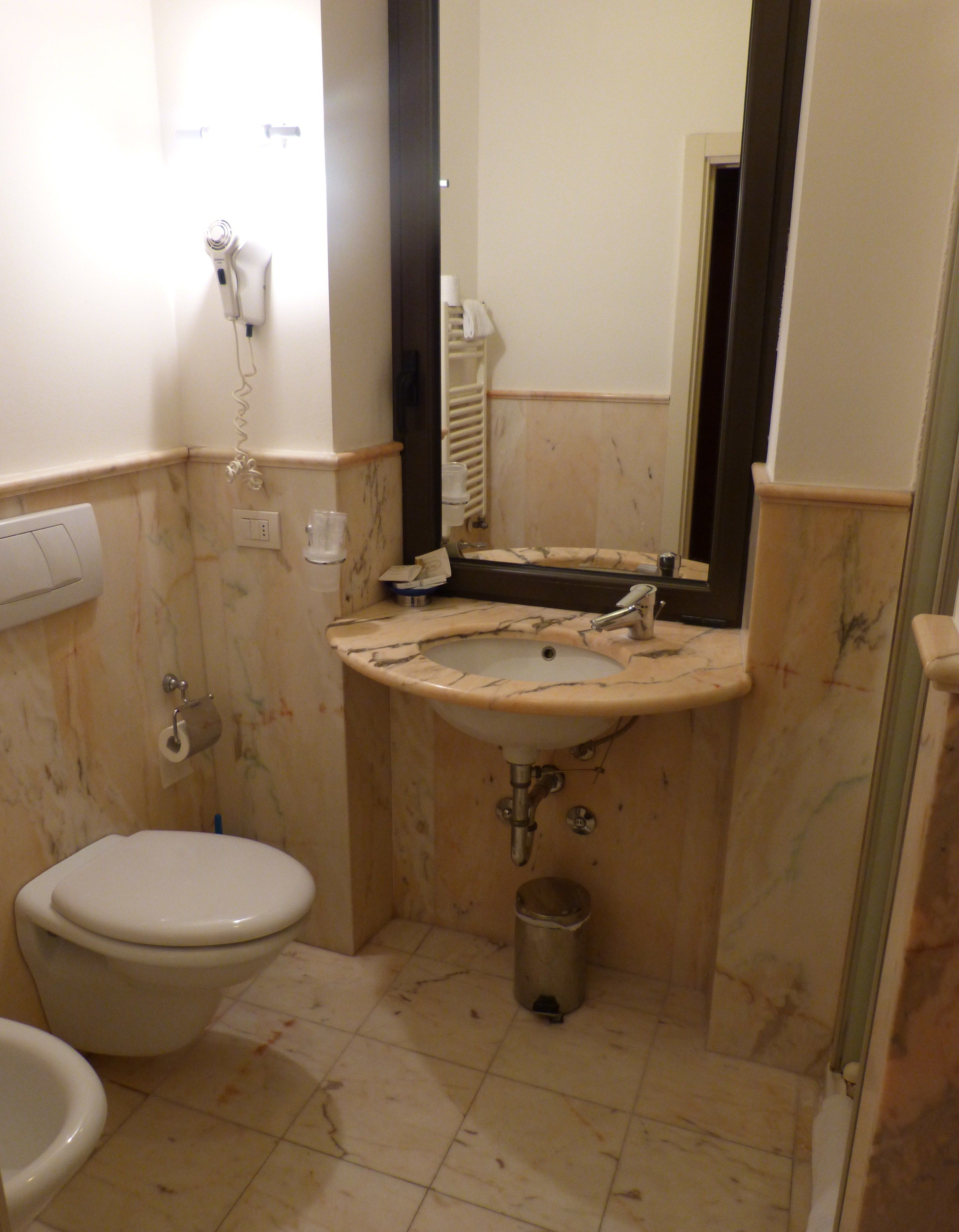 Un baño con inodoro, lavabo y espejo.