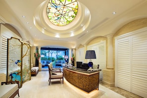 A hotel lobby with a reception desk, seating area, and a large stained glass window. - Seaview Resort Xiamen (Xiamen)