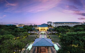 A hotel with a central courtyard, a fountain, and a pool area.