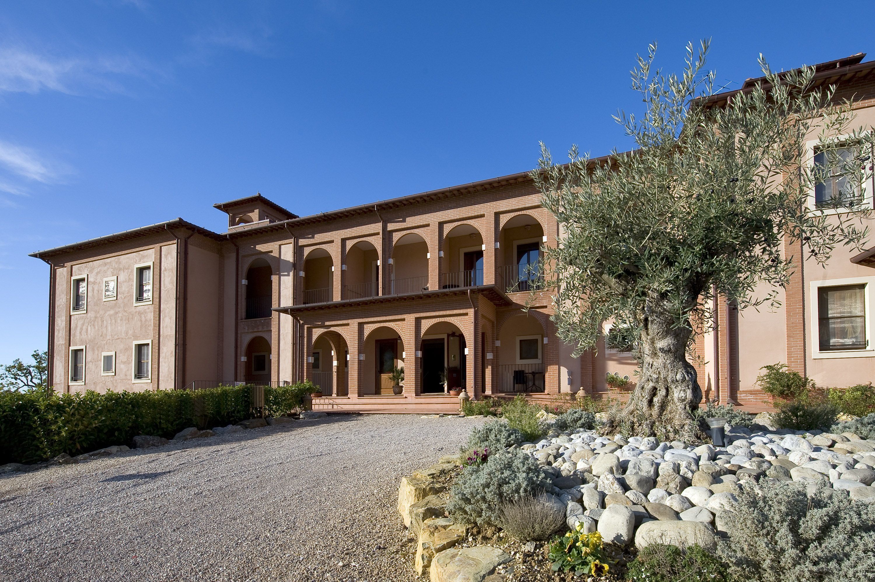 A large, multi-story building with a symmetrical facade, featuring arched windows and a central courtyard.