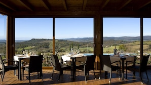 Un coin repas avec une table dressée pour quatre personnes, offrant une vue sur un paysage magnifique.