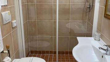 Un bagno con cabina doccia, toilette, bidet e lavandino.