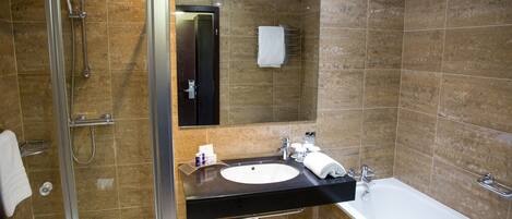 A modern bathroom with a glass-enclosed shower, a black sink with a white basin, and a white bathtub.