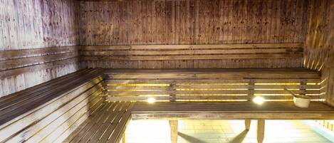 A sauna with wooden benches and a tiled floor.
