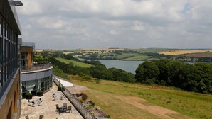 A terrace with outdoor seating, overlooking a lake and rolling hills. - Kinsale Hotel & Spa (Kinsale)