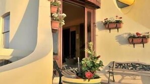 A building with a curved yellow facade and a sign that reads "AMBASSADO". - Ambassador Hotel (St. Paul's Bay)