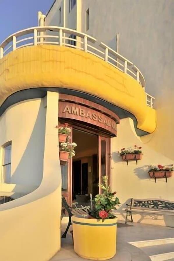A building with a curved yellow facade and a sign that reads "AMBASSADO". - Ambassador Hotel (St. Paul's Bay)