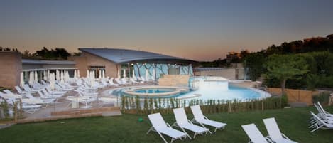 Un área de piscina con sillas de descanso y un jacuzzi.
