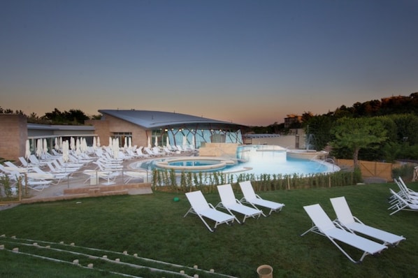 A pool area with lounge chairs and a hot tub. - Albergo Angiolino (Chianciano Terme)