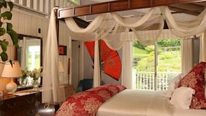 Un dormitorio con cama a dosel, cómoda, espejo y vistas al exterior.