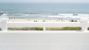 Vista de playa con un muro blanco al frente.