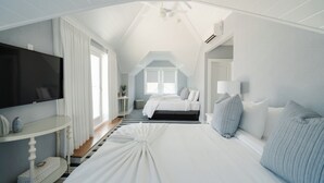 Un dormitorio con cama, televisión, mesita de noche y ventana.