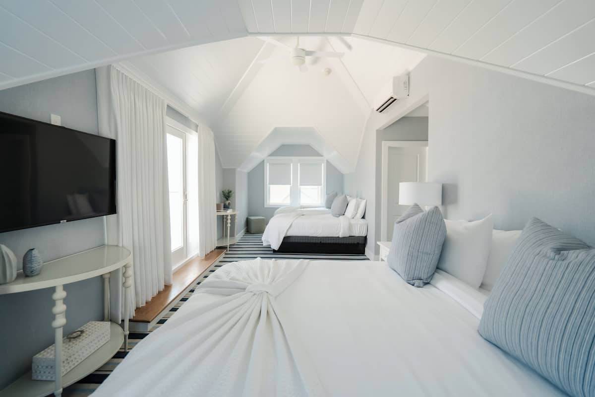 Ein Schlafzimmer mit Bett, Fernseher, Nachttisch und Fenster.