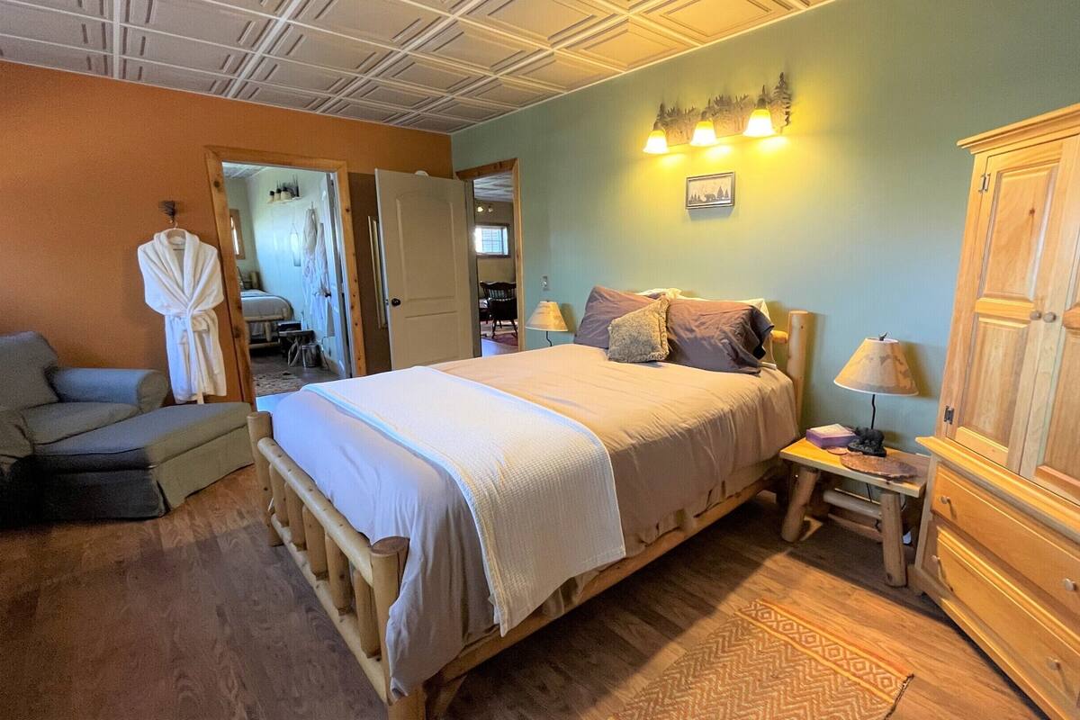 A bedroom with a bed, a nightstand, a wardrobe, and a chair.