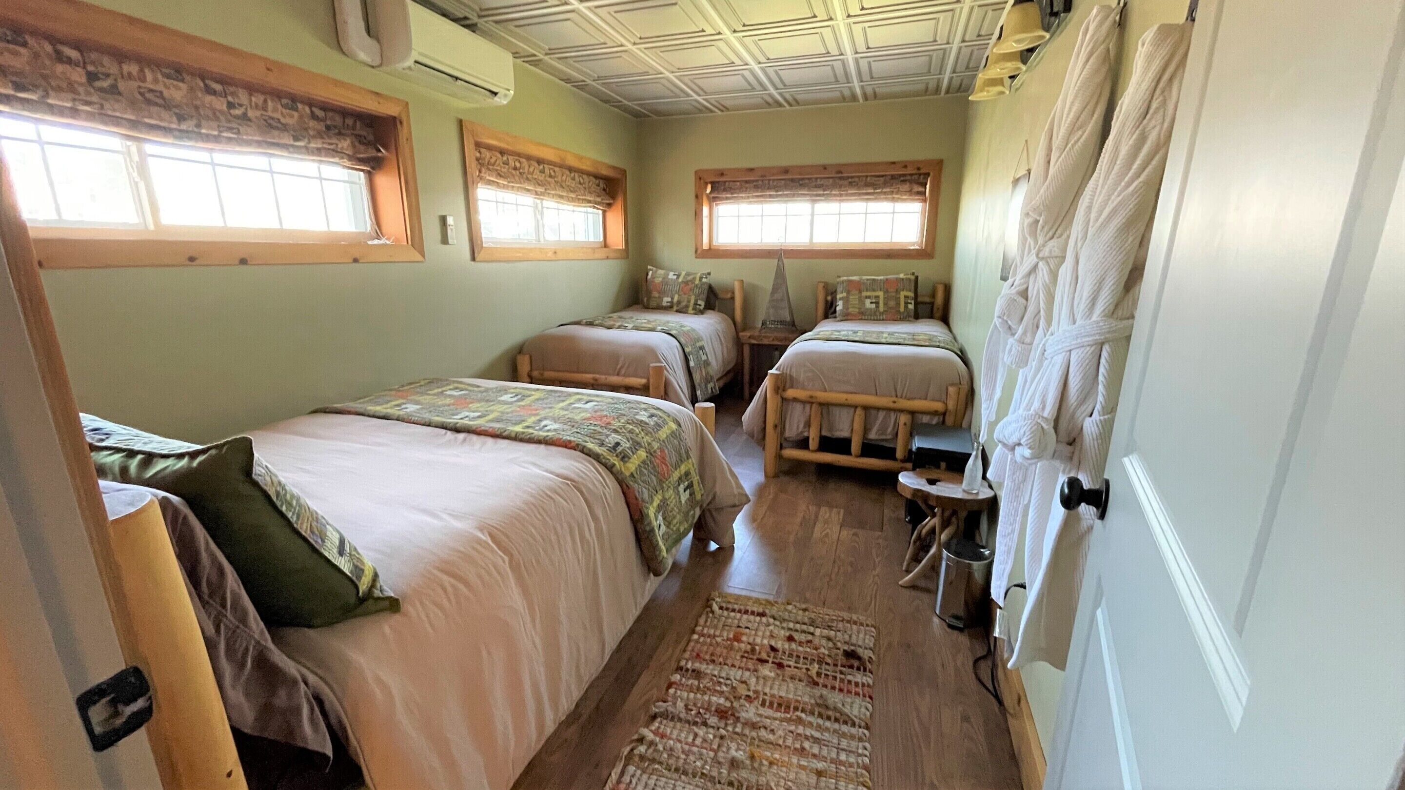 A room with two beds, a small table, and a window.