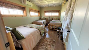 A room with two beds, a small table, and a window.