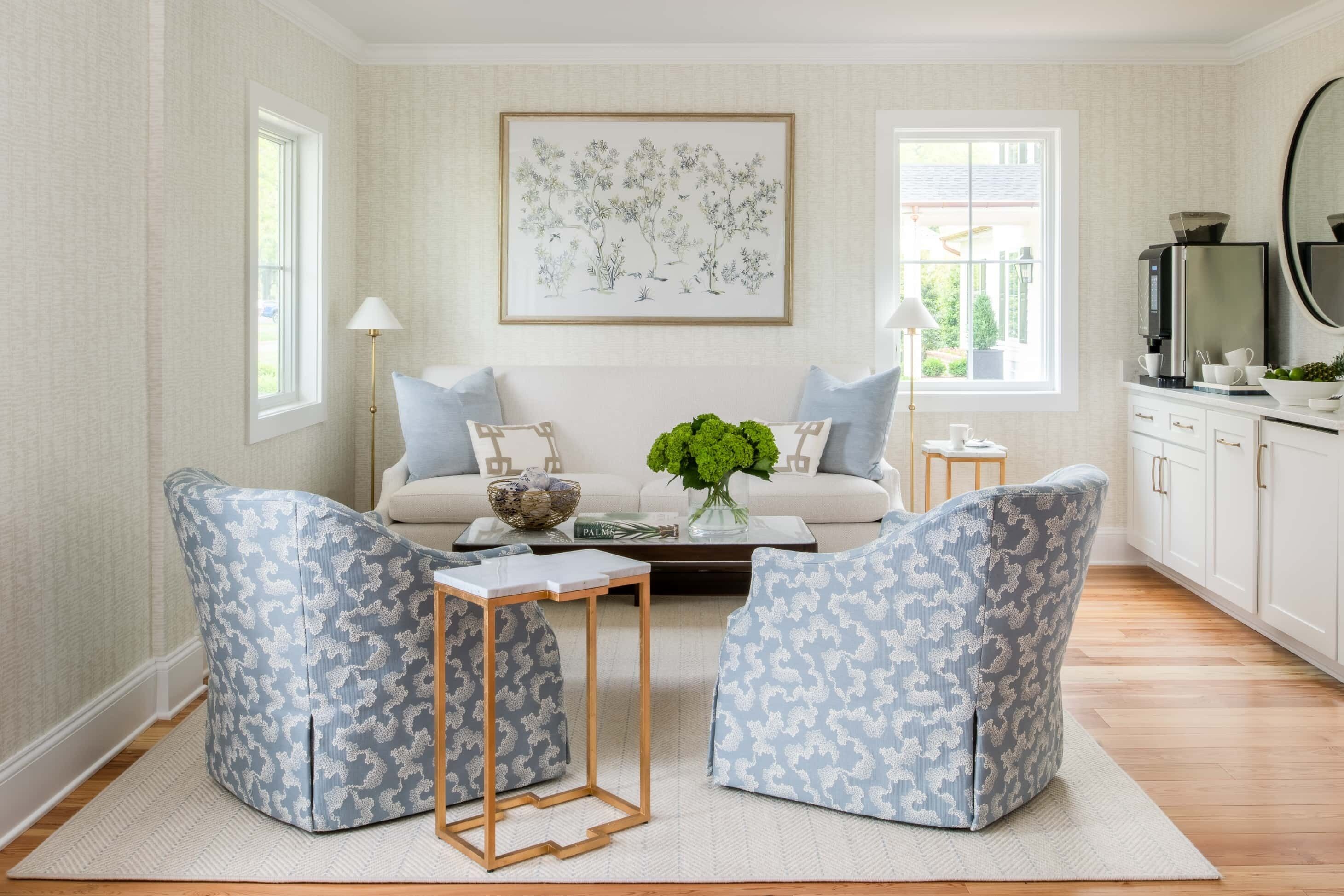 A living room with a sofa, two armchairs, a coffee table, and a painting on the wall.