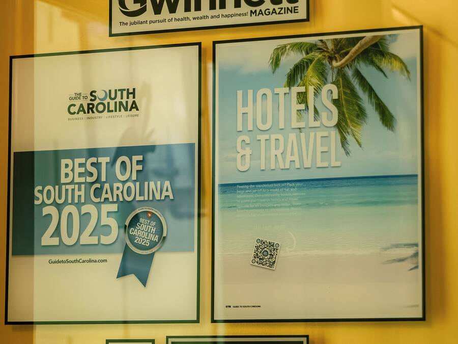 Two framed awards for 'Best of South Carolina 2025' and 'Hotels & Travel' by Gwinnett Magazine, including a QR code and a plaque for Water's Edge Inn.