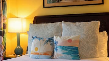 A hotel room with a bed, a nightstand, a lamp, and a painting on the wall.