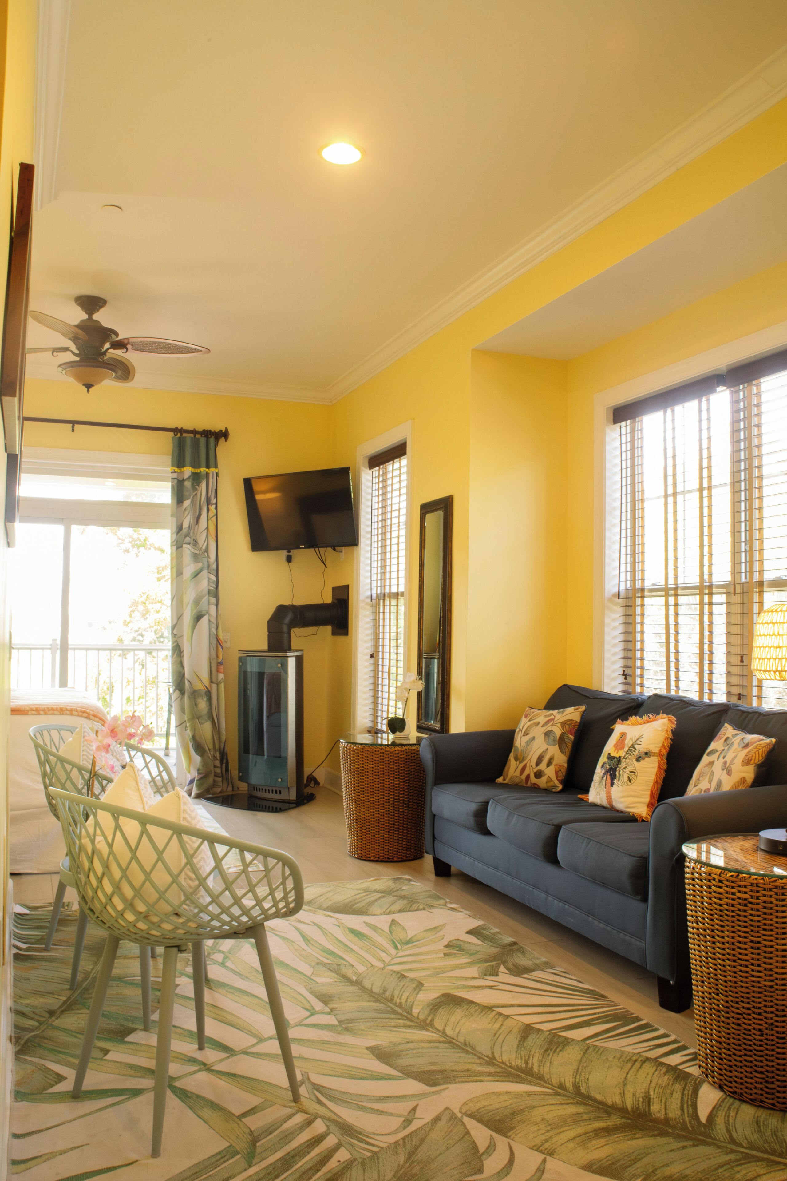A living room with a sofa, a television, and a ceiling fan.