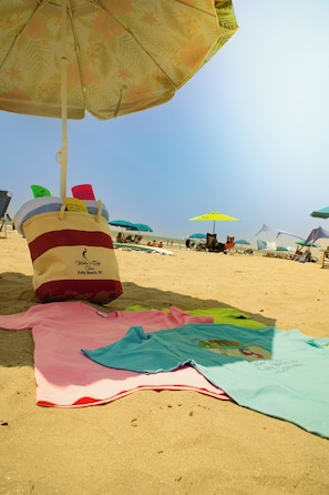 A beach scene with multiple umbrellas and beach chairs.