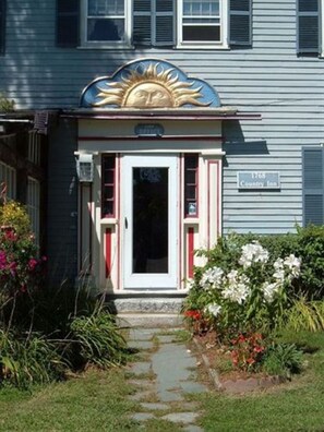 A building with a blue exterior, a white door, and a sign indicating it is the 1768 Country Inn. - 1768 Country Inn (North Conway)
