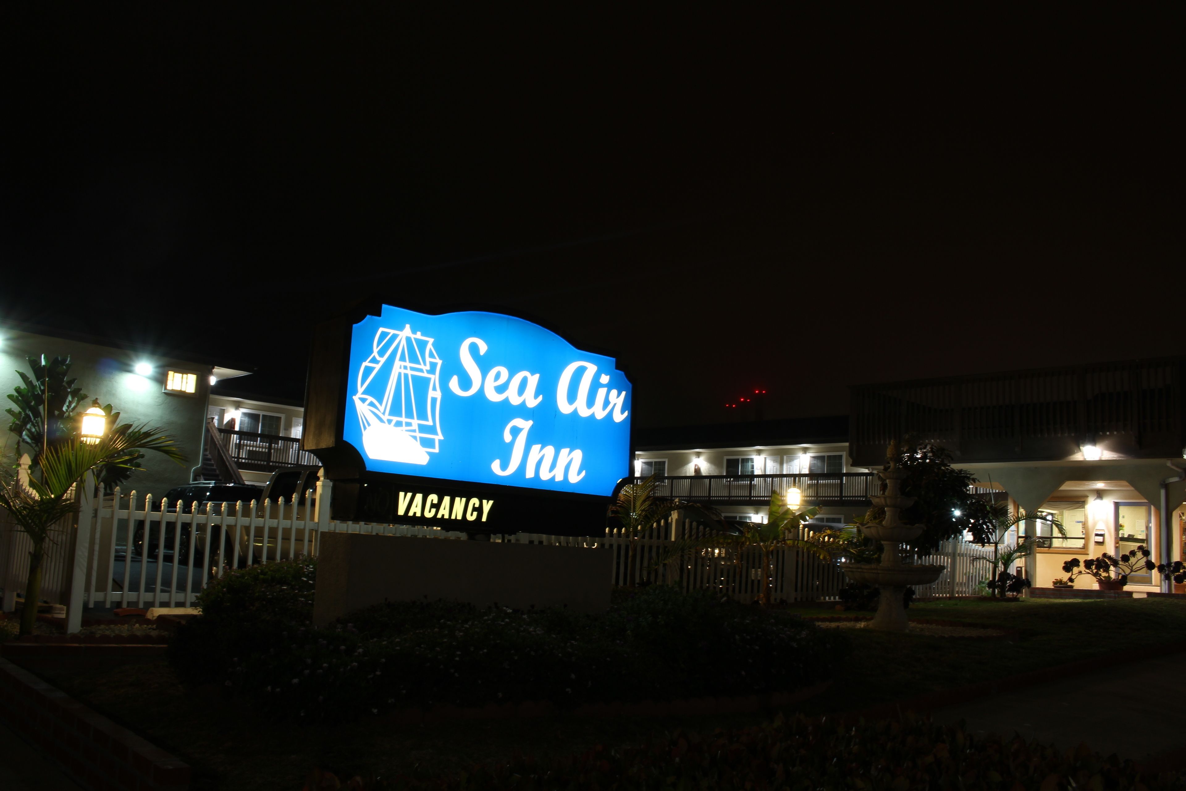 Ein großes, beleuchtetes Schild für das Sea Air Inn mit der Aufschrift 'FREIE ZIMMER'.