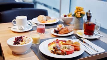 A breakfast table with various dishes including cereal, eggs, bacon, and toast.
