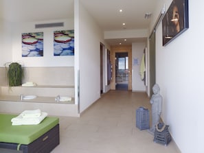 Een moderne badkamer met een grote spiegel, een groene badmat en een beeldje.