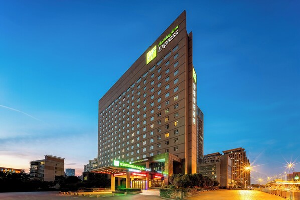 A tall hotel building with a prominent sign for Holiday Inn Express.
