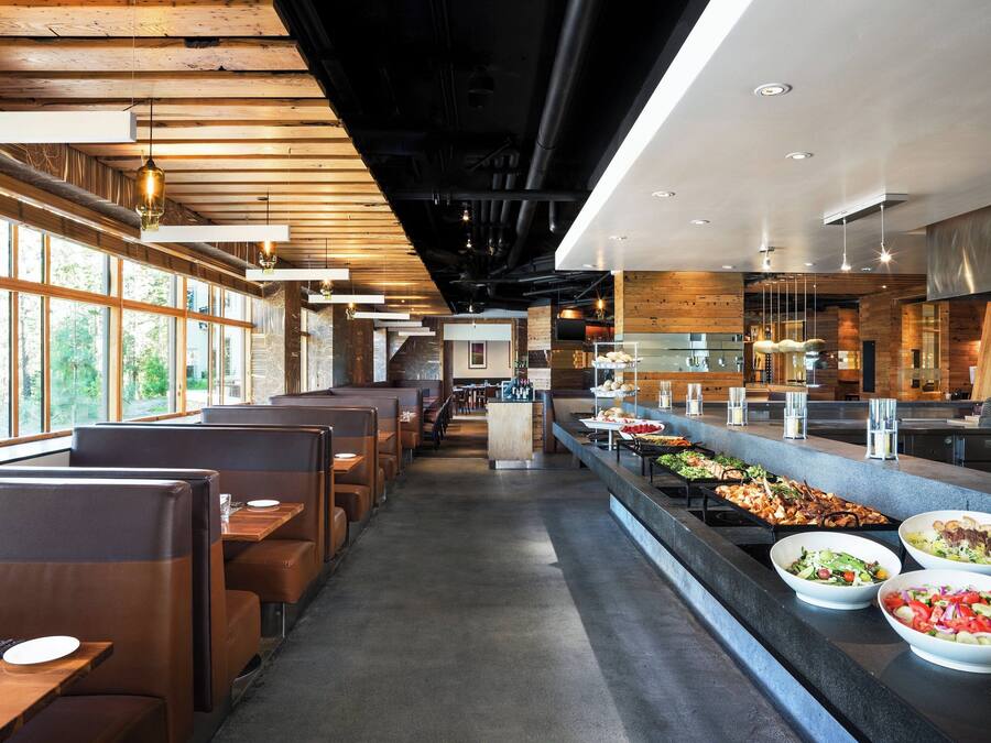 A restaurant with booth seating, a buffet with various dishes, and a view of the outdoors.