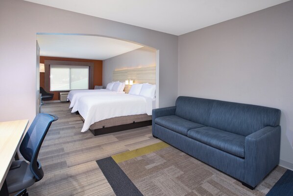 Een hotelkamer met een groot bed, een bank, een bureau en een stoel.