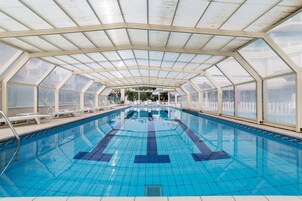 Una piscina al aire libre de temporada, sombrillas