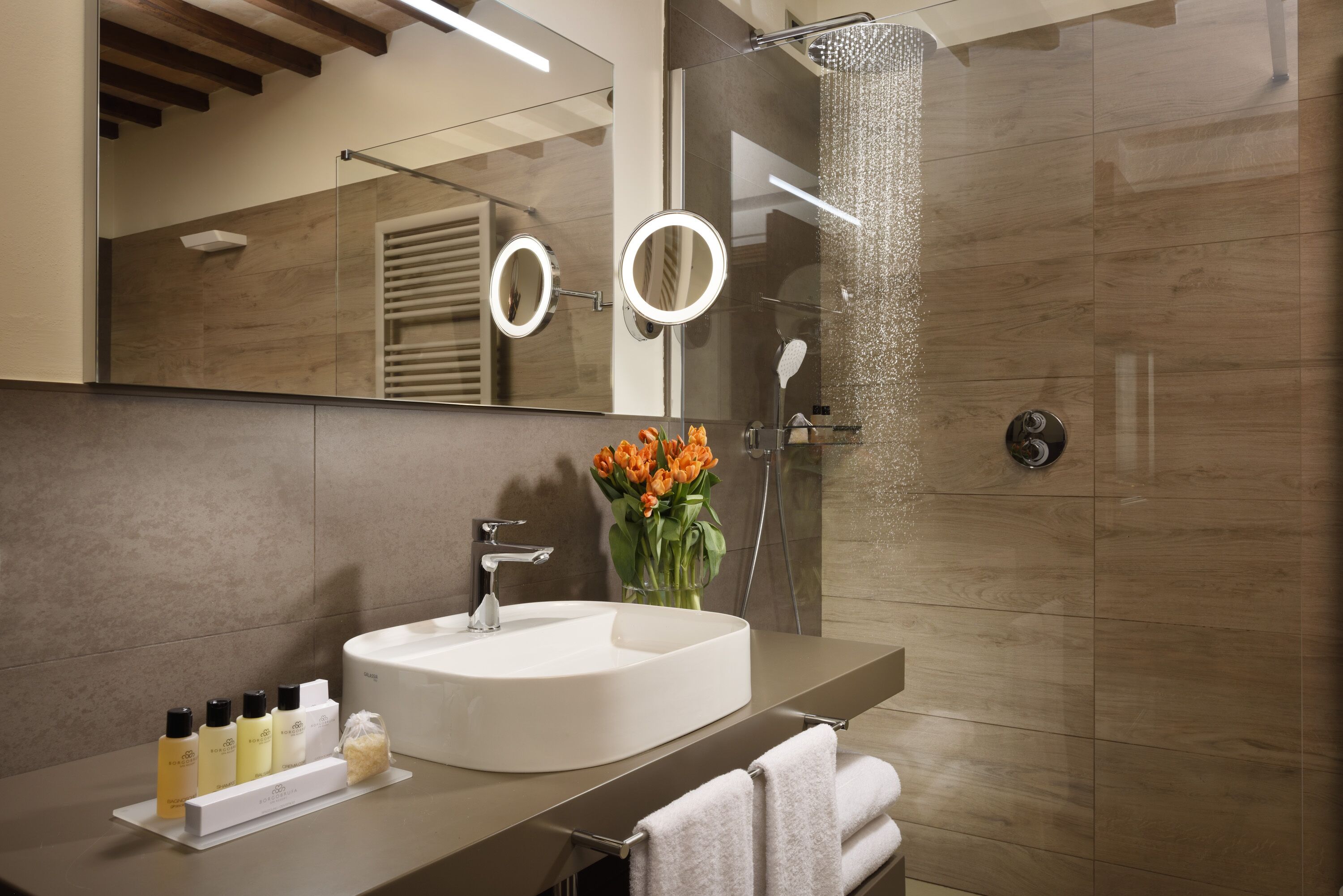 Un bagno moderno con uno specchio grande, un lavandino e una doccia.