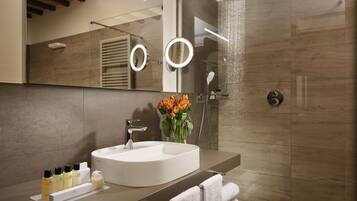 Un bagno moderno con uno specchio grande, un lavandino e una doccia.