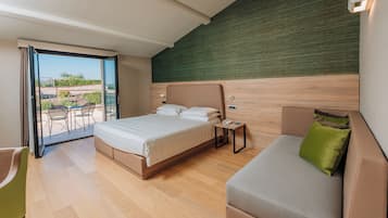 Quarto moderno com cama, sofá, mesinha e porta de vidro deslizante para área externa.