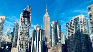 A cityscape with modern high-rise buildings, including a prominent skyscraper with a spire. - Holiday Inn Manhattan 6th Ave - Chelsea by IHG (New York)
